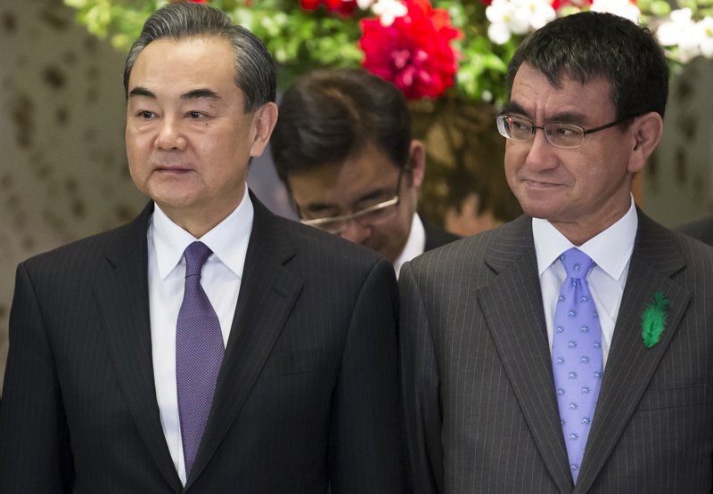 Chinese Foreign Minister Wang Yi, left, stands with his Japanese counterpart Taro Kono during a photo session before the start of the Japan-China High-Level Economic Dialogue in Tokyo Monday, April 16, 2018.  Photo: AP