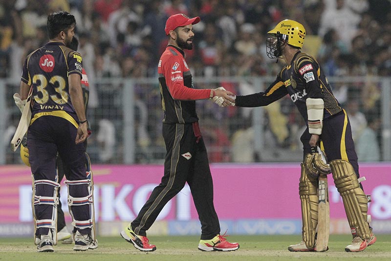 Royal Challengers Bangalore's Virat Kohli, (cenre)r shakes hands with Kolkata Knight Riders' Dinesh Karthik for their win as Vinay Kumar, left looks on during VIVO IPL cricket T20 match in Kolkata, India, on Sunday, April 8, 2018. Photo: AP