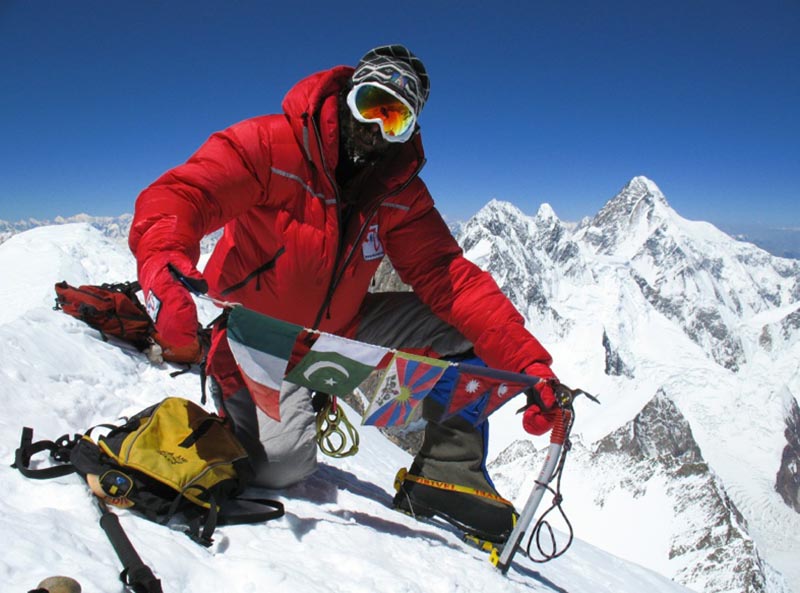 File - Italian climber Simone La Terra holding flags on a mountain summit. Photo: simonelaterra.it