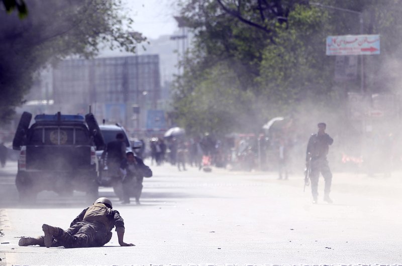 A security force and a civilian lie low at the site of a suicide attack after the second bombing in Kabul, Afghanistan, on Monday, April 30, 2018. Photo: AP