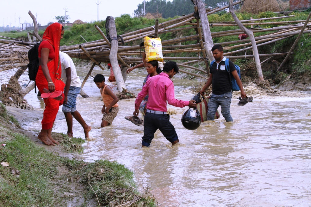 People are seen crossing the Khando Khola after the the bamboo bridge over it was damaged in Dashgaja of Tilathi Koilaadi Rural Municipality-1, Saptari district, on Wednesday, April 18, 2018. Photo: Byas Shankar Upadhyay