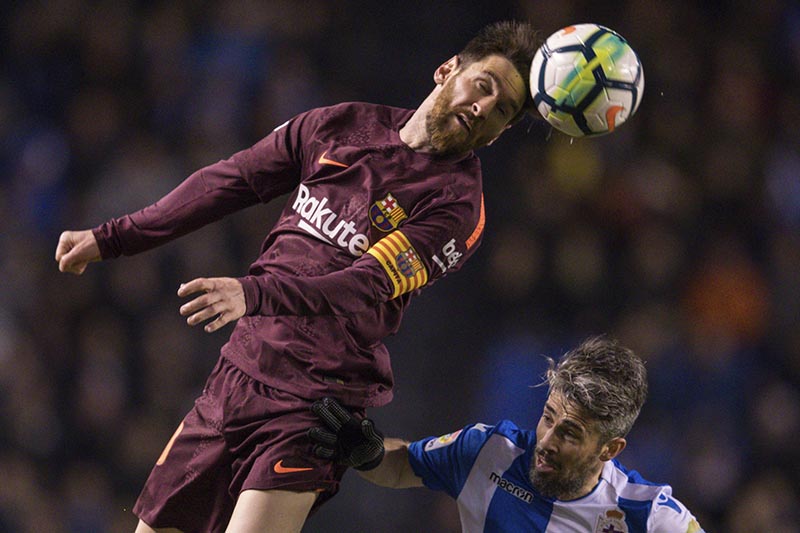 Barcelona's Lionel Messi, left, challenges for the ball with Deportivo's Luisinho during a Spanish La Liga soccer match between Deportivo and Barcelona at the Riazor stadium in A Coruna, Spain, on Sunday, April 29, 2018. Photo: AP