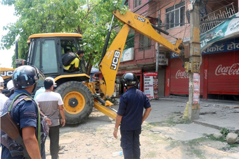 A dozer being used to dismentle illegally built structrues along Butwal-Belihiya road section for road expansion project in Butwal Sub Metropolitan City, on Wednesday, April 25, 2018. Photo: RSS