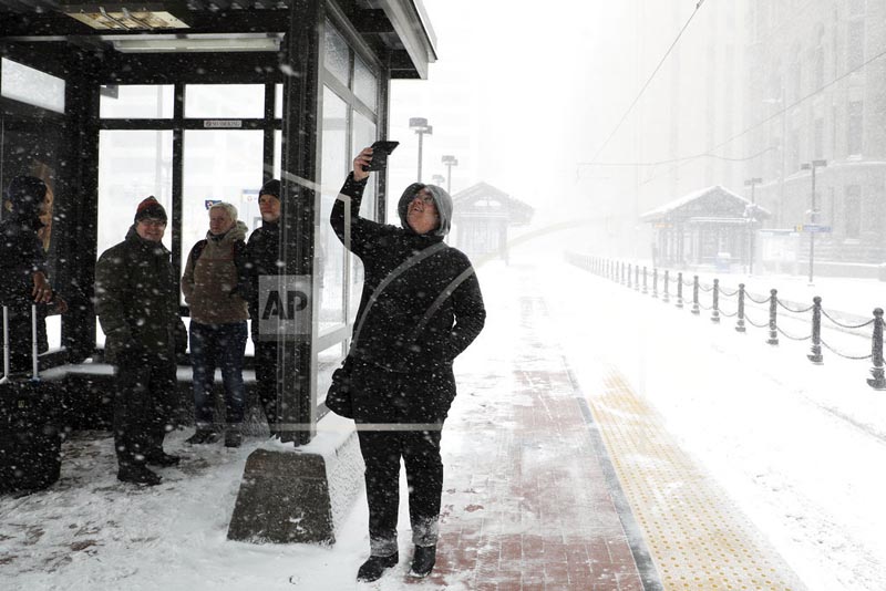 Travelers at the Metro Government Center Plaza station wait for a train as the snow picked up in downtown Minneapolis, Saturday, April 14, 2018. Photo: AP