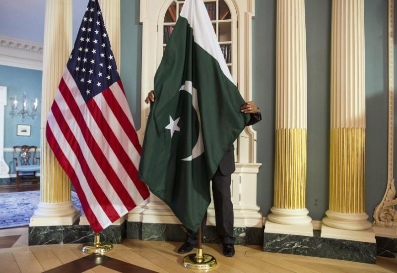 FILE PHOTO: A State Department contractor adjust a Pakistan national flag before a meeting between U.S. Secretary of State John Kerry and Pakistan's Interior Minister Chaudhry Nisar Ali Khan on the sidelines of the White House Summit on Countering Violent Extremism at the State Department in Washington February 19, 2015.      REUTERS/Joshua Roberts