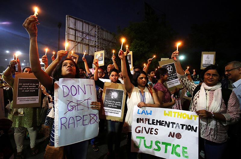 FILE PHOTO: People hold candles and placards during a protest against the rape of an eight-year-old girl, in Kathua, near Jammu, a teenager in Unnao, Uttar Pradesh, and an eleven-year-old girl in Surat, Gujarat, in Ahmedabad, Indiia, on April 16, 2018. Photo: Reuters