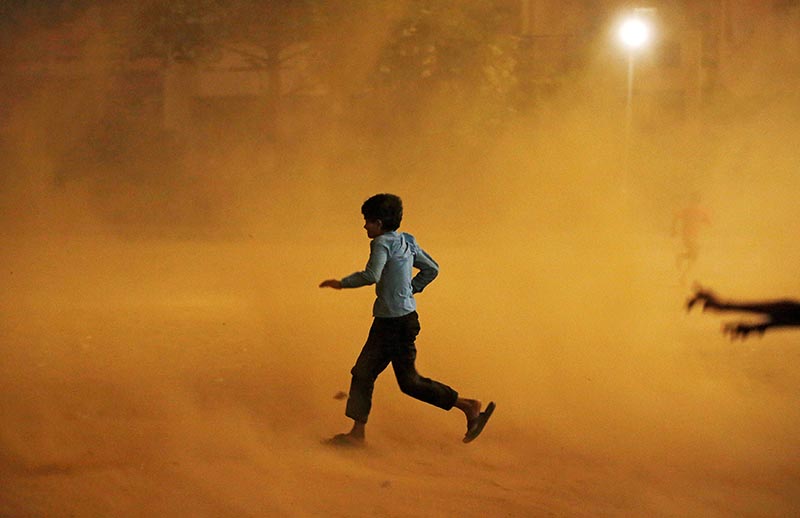 A boy runs for cover during a dust storm in New Delhi, India, on May 13, 2018. Photo: Reuters