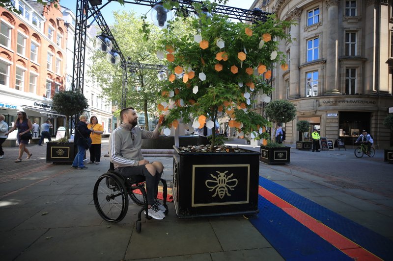 Martin Hibbertt, who suffered life-changing injuries in the Manchester terror attack, reads messages left on a u2018Tree of Hopeu2019 in St Annu2019s Square, Manchester, England ahead of the Manchester Arena National Service of Commemoration at Manchester Cathedral to mark one year since the attack, on Tuesday May 22, 2018. Photo: APn