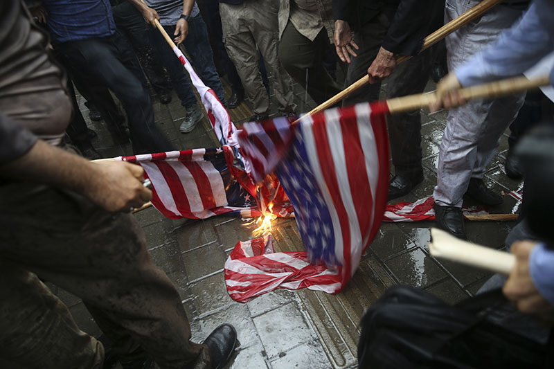 FILE PHOTO - Iranian demonstrators burn representations of the U.S. flag during a protest in front of the former U.S. Embassy in response to President Donald Trump's decision to pull out of the nuclear deal and renew sanctions, in Tehran, Iran,on Wednesday,May 9, 2018. Photo: Associated Press