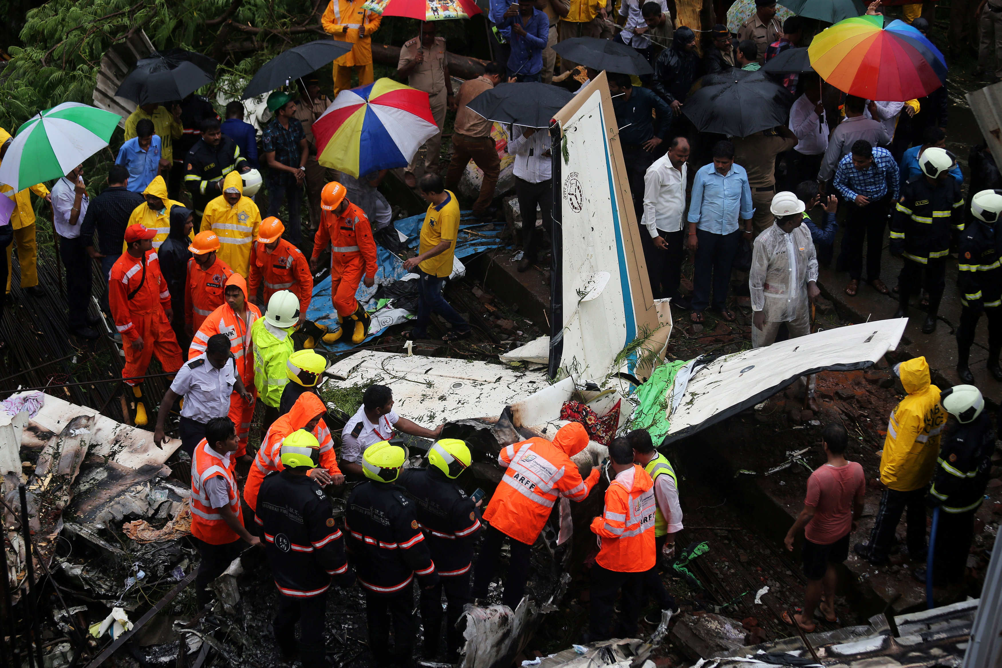Firefighters and aircraft rescue workers inspect the site of a plane crash in Mumbai, India June 28, 2018. PHOTO: REUTERS