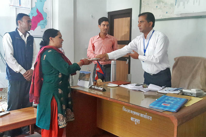 Bajura Chief District Officer Chet Raj Baral handing over relief amount to mother of Nabin Padhaya in the district. Photo: Prakash Singh