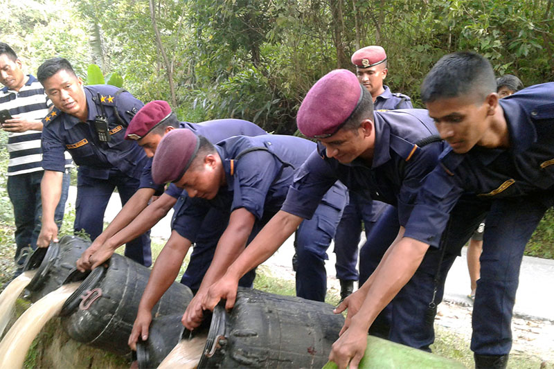 Police personnel seen draining confiscated bootleg liquor produced at various small-scale hotels around Lamjung, Besi Shahar on Wednesday, June 20, 2018. Photo: Ramji Rana