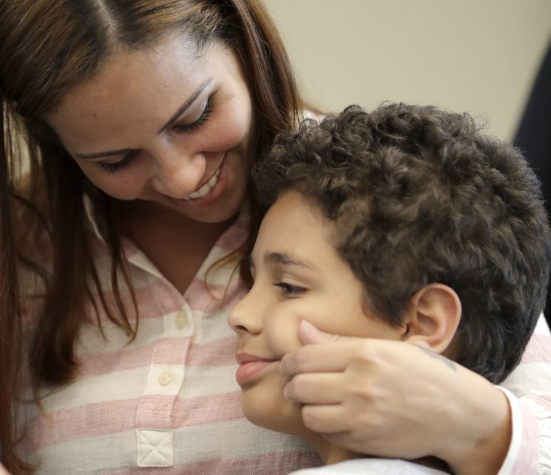 Lidia Karine Souza smiles and pinches the cheek of her son Diogo at the Mayer Brown law firm during a news conference shortly after Diogo was reunited with his mother on Thursday, June 28, 2018, in Chicago. Photo: AP