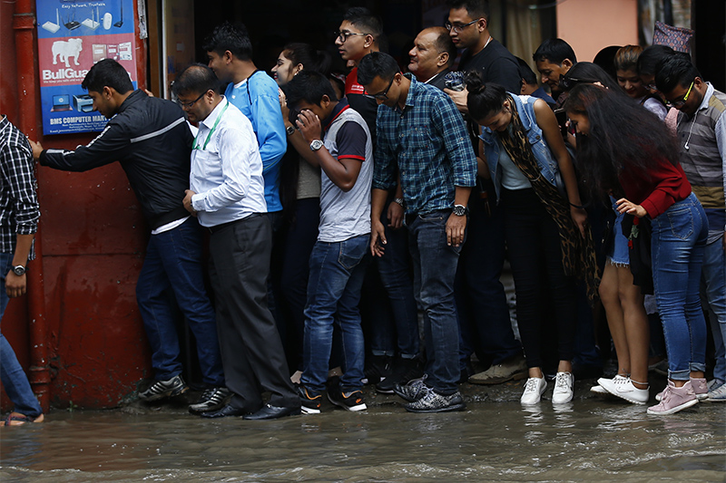 Crowd of pedestrians stuck trying to get across a waterlogged road after brief rain showers in Kathmandu, Nepal on Sunday, June 03, 2018.