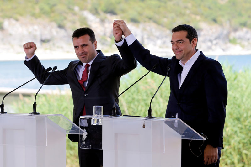 Greek Prime Minister Alexis Tsipras and Macedonian Prime Minister Zoran Zaev gesture before the signing of an accord to settle a long dispute over the former Yugoslav republic's name in the village of Psarades, in Prespes, Greece, June 17, 2018. REUTERS/Alkis Konstantinidis TPX IMAGES OF THE DAY