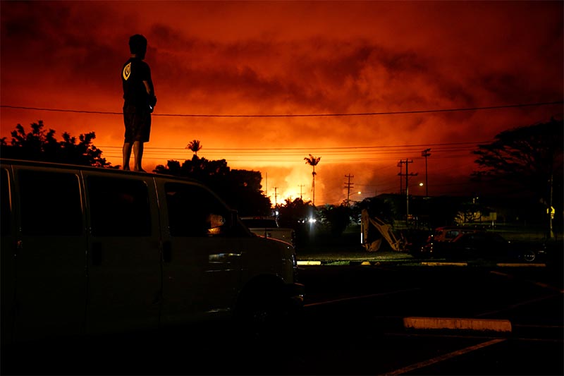 Darryl Sumiki, 52, of Hilo, watches as lava lights up the sky above Pahoa during ongoing eruptions of the Kilauea Volcano in Hawaii, US, June 2, 2018. Photo: Reuters