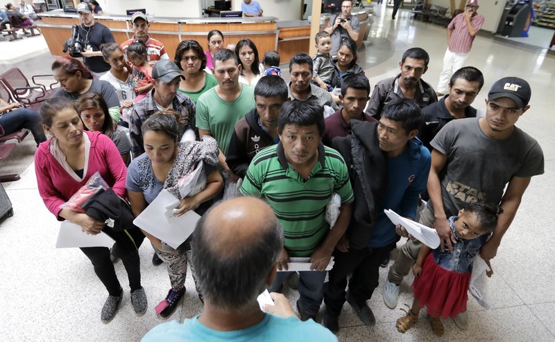 Immigrants listen to instructions from a volunteer inside the bus station after they were processed and released by U.S. Customs and Border Protection, on Friday, June 22, 2018, in McAllen, Texas. n