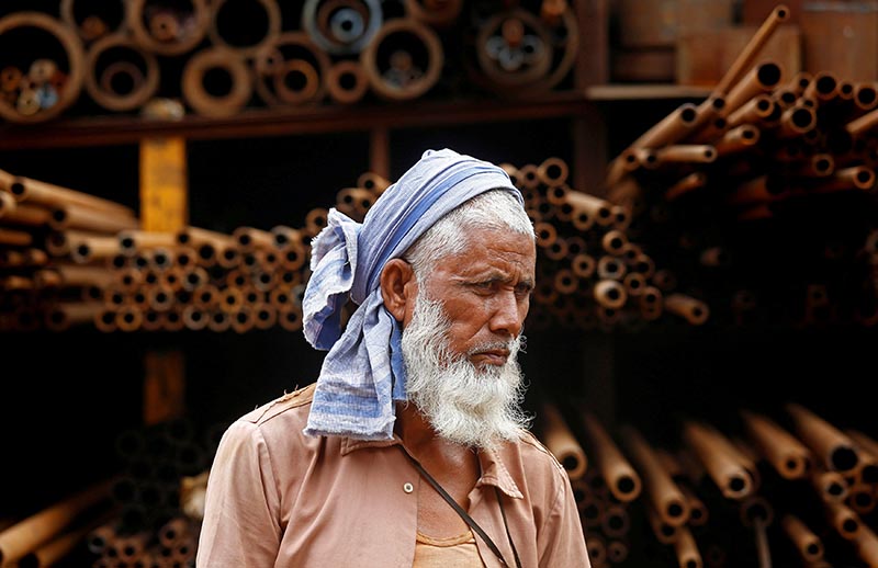 A labourer stands in front of a steel pipe storage rack at an industrial area in Mumbai, India, January 12, 2018. Photo: Reuters/ File
