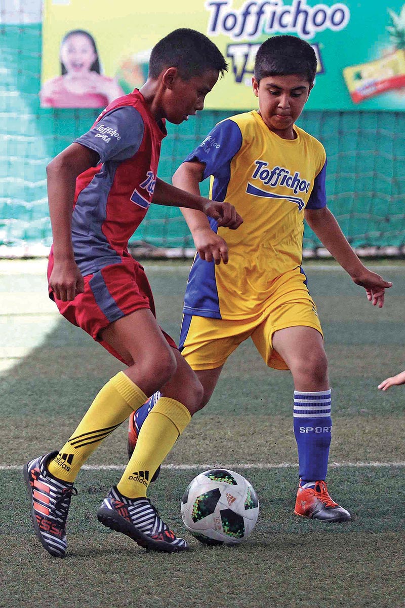 Players of Nightangle School (left) and GEMS School vie for the ball in Boys U-12 during Toffichoo Junior Champions Cup, inter-school futsal tournament at National Sports Centre, Chyasal in Lalitpur on Tuesday. Photo: THT