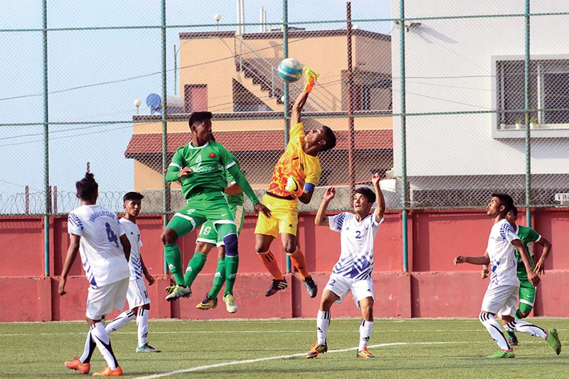Saraswoti Youth Club goalkeeper jumps to save the ball under pressure from his Tribhuvan Army Club opponent during their Lalitu00a0Memorial U-18 Championship match at the ANFA Complex grounds in Lalitpur on Tuesday. Photo: THT