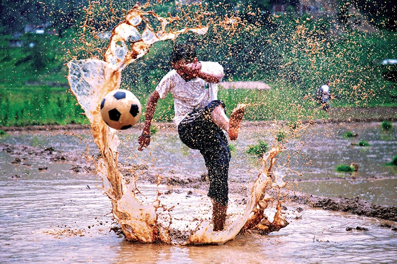 A man kicking a football as he takes part in an event celebrating National Paddy Day, also called Asar Pandhra, that marks the commencement of rice crop planting in paddy fields as monsoon season arrives, in Lalitpur, on Friday,  June 29, 2018. Photo: Reuters