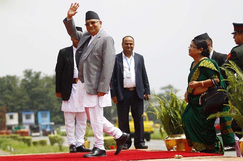 Prime Minister KP Sharma Oli waving upon arrival after a six-day official visit to China at Tribhuvan nInternational Airport, Kathmandu, on Sunday, June 24, 2018. Photo: THT