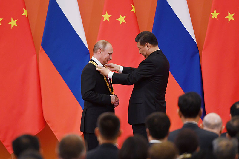 Chinese President Xi Jinping (R) presents Russian President Vladimir Putin with the Friendship Medal in the Great Hall of the People in Beijing, China June 8, 2018. Greg Baker/Pool/via REUTERS