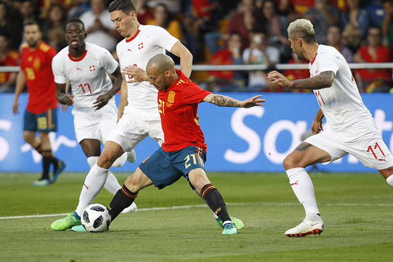 Spain's Silva, center, fights for the ball Switzerland players during the friendly soccer match between Spain and Switzerland at the Ceramica stadium in Villarreal, Spain, on Sunday, June 3, 2018. Photo: AP