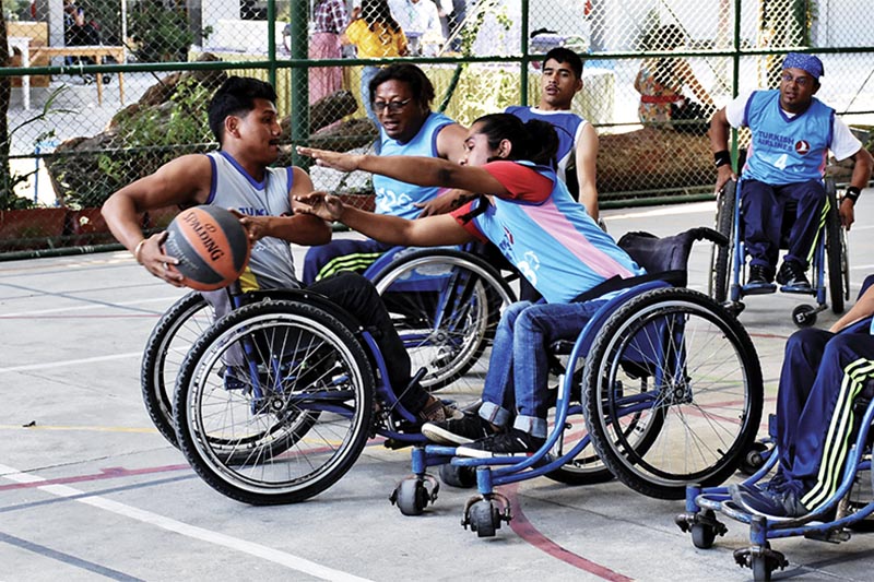Players of Wheelchair Sports Association (left) and BodhisatwasIn Action vie for the ball during their Turkish Airlines Engage Empowering League match in Lalitpur on Sunday. Photo: THT