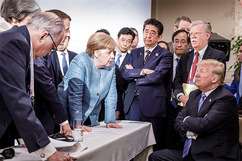 German Chancellor Angela Merkel speaks to US President Donald Trump during the second day of the G7 meeting in Charlevoix city of La Malbaie, Quebec, Canada, on June 9, 2018.