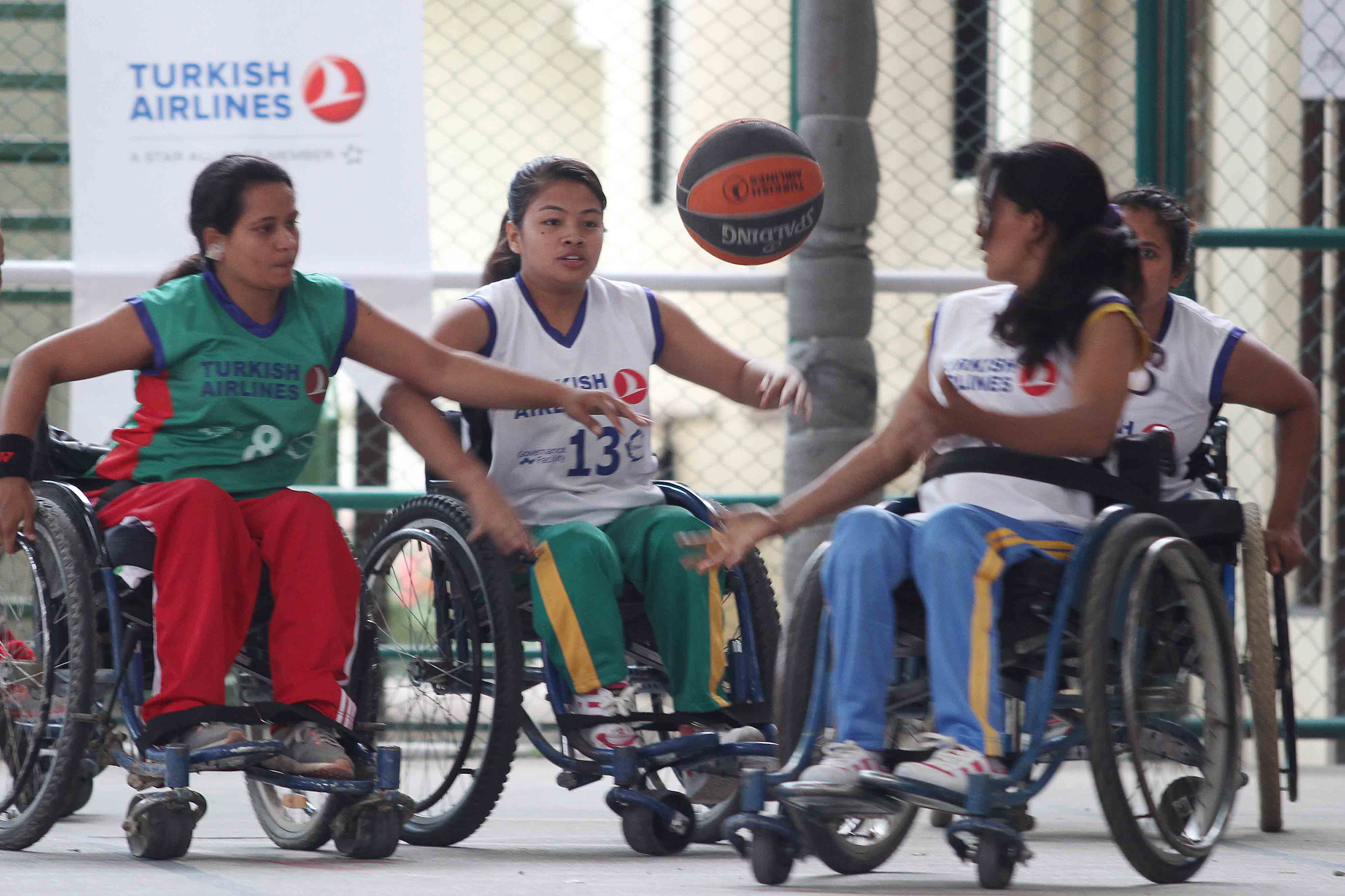 A player of Nepal Spinal Cord Injury Sprots Association (left) vies for the ball against players of Women Wheelchair Basketball Association during their Turkish Airlines Engage Empowering League at the British School, Jhamsikhel in Lalitpur on Saturday, June 2, 2018. Photo: THT