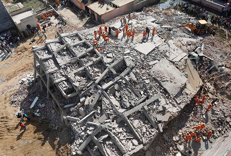 Rescue workers look for survivors amidst the rubble at the site of a collapsed residential building at Shah Beri village in Greater Noida, India, July 18, 2018. Photo: Reuters