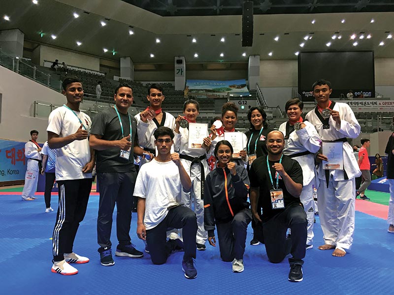 Nepali taekwondo players pose for a photo with coaches Deepak Bista and Sangina Baidya in Pohang, South Korea on Thursday.
