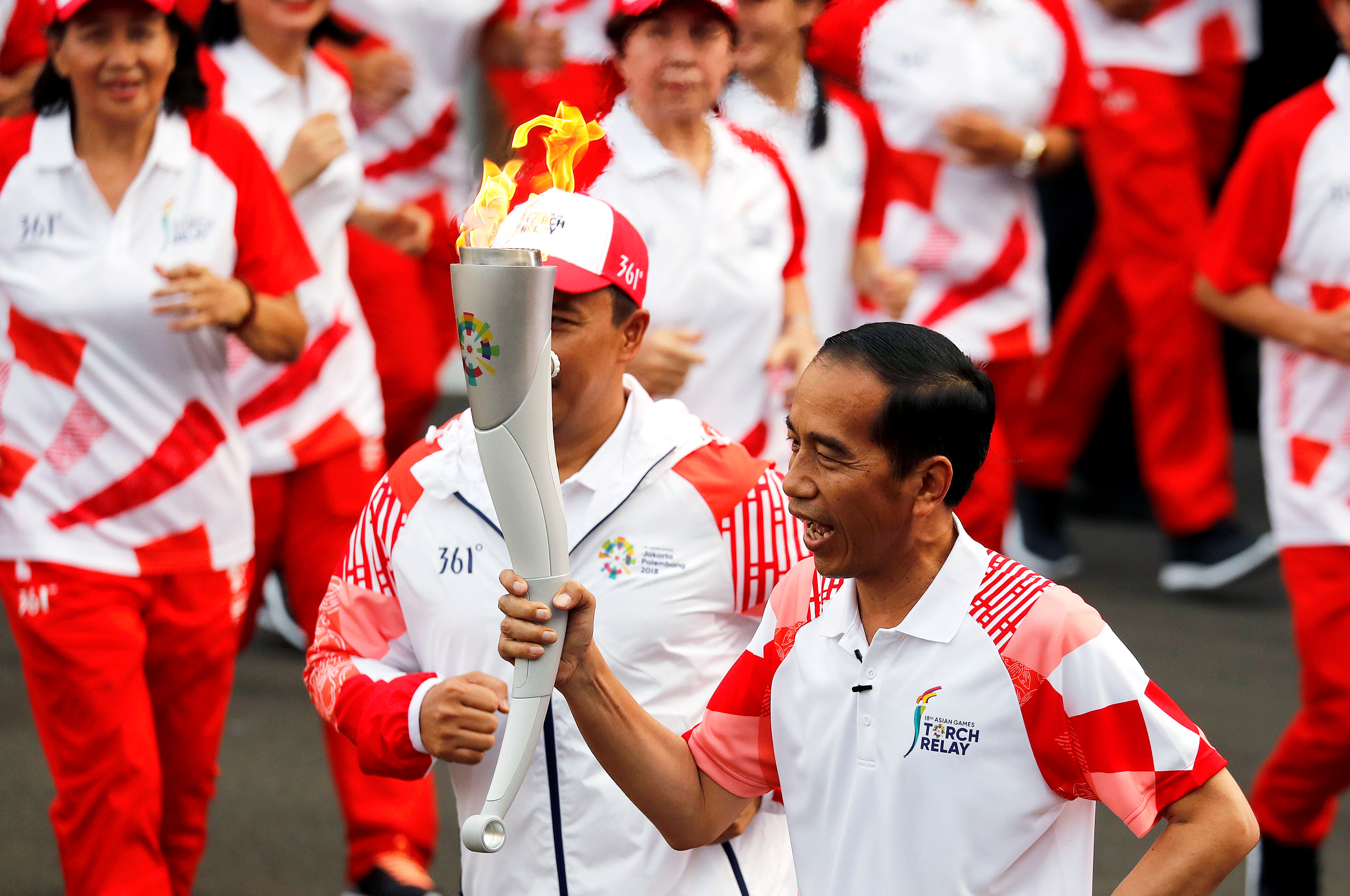 Indonesian President Joko Widodo carries the Asian Games torch at the Asian Games 2018 torch relay ahead of the August 18 - September 2 games held in Jakarta and Palembang, at the presidential palace in Jakarta, Indonesia August 17, 2018. REUTERS