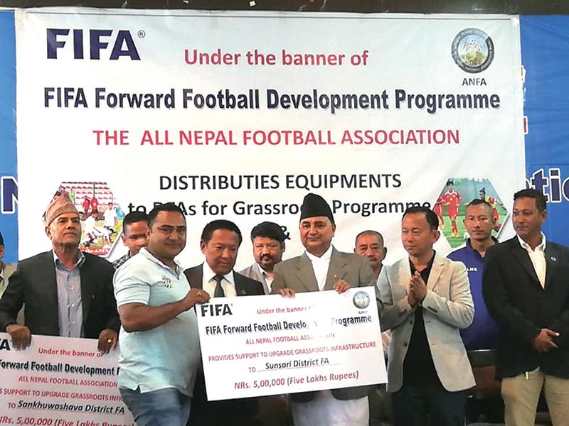 Deputy PM and Defense Minister Ishwor Pokhrel (right) and ANFA President Karma Tsering Sherpa (centre) handing over the fund and equipment to Sunsari FA representative, in Lalitpur on Tuesday. Photo: THT