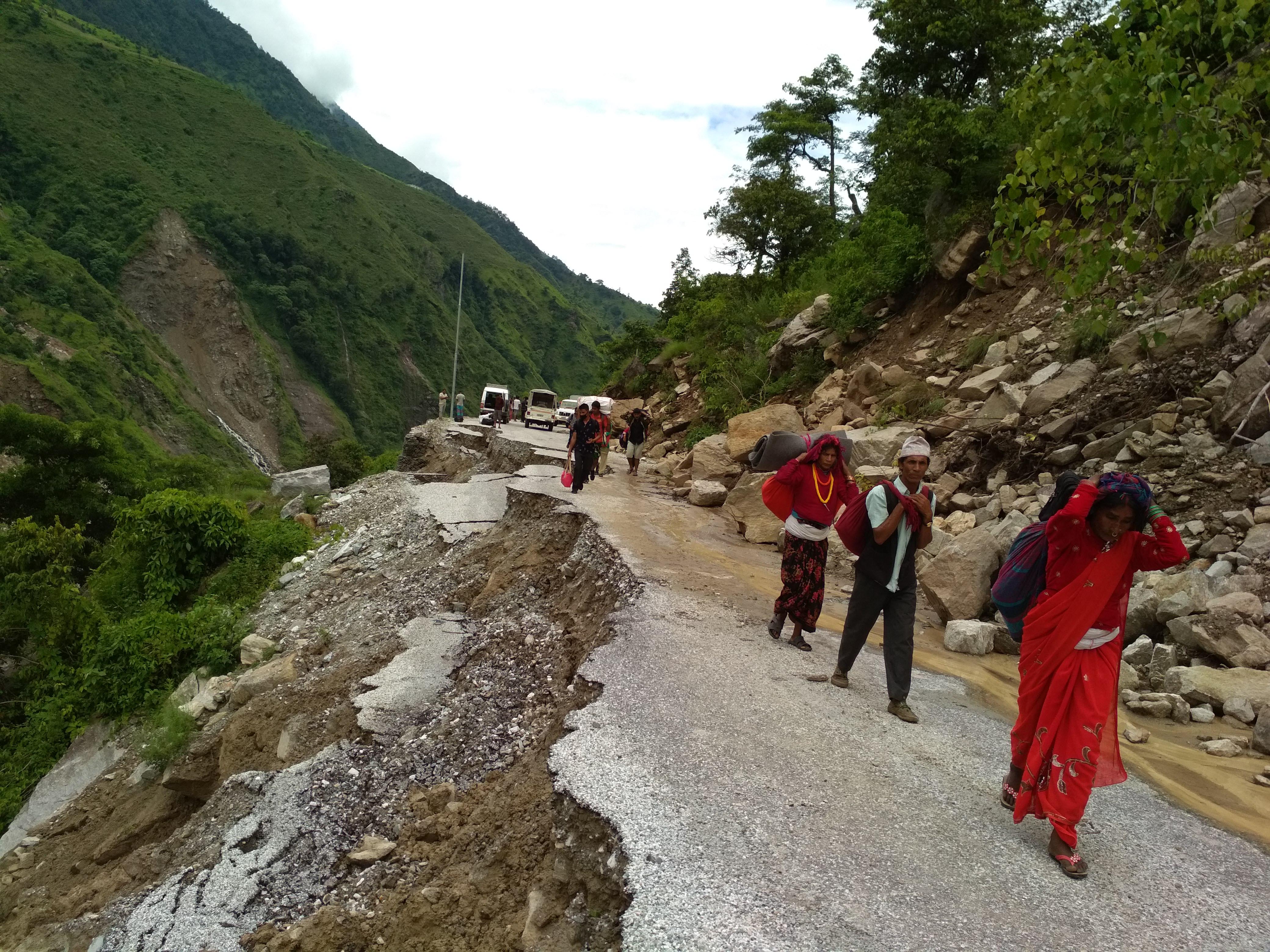 Displaced families walk away from their villages battered by torrential rain and landslides seeking safe shelters in Bajura on August 18, 2018. Photo: Prakash Singh