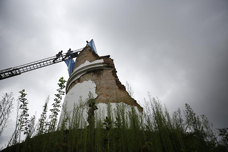 Firefighters climbing up a ladder to cover the remains of Dharahara with tarpaulin to prevent it from rains, in Kathmandu, on Wednesday, August 1, 2018. Photo: Skanda Gautam/THT