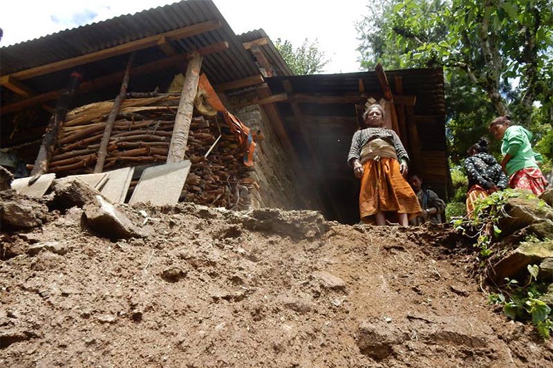 A woman standing in front of her house, which is on the brink of being swept away in a landslide, in Dolakha, on Monday, August 20, 2018. Photo: THT