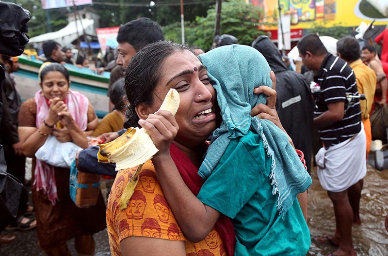 A woman cries as she holds her son after they were evacuated from a flooded area in Aluva in the southern state of Kerala, India, on August 18, 2018. Photo: Reuters