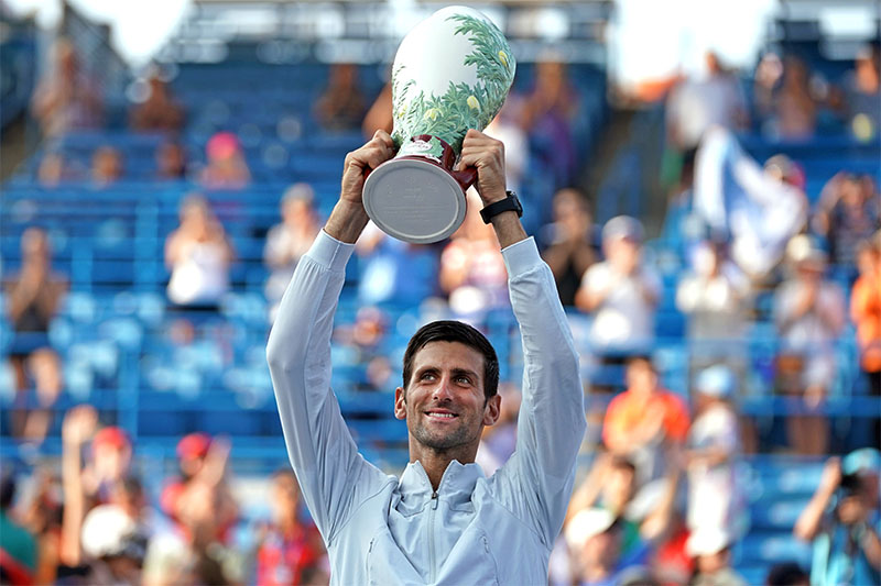 Novak Djokovic (SRB) poses for photos while holding the Rookwood Cup after defeating Roger Federer (SUI) during the finals in the Western and Southern tennis open at Lindner Family Tennis Center. Mandatory Credit: Aaron Doster-USA TODAY Sports