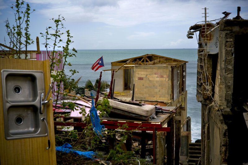 FILE - In this photo, a Puerto Rican national flag is mounted on debris of a damaged home in the aftermath of Hurricane Maria in the seaside slum La Perla, San Juan, Puerto Rico on Oct. 5, 2017. Photo: AP