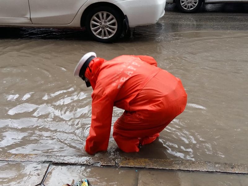 A traffic police personnel is seen clearing the drainage on the waterlogged road in Putalisadak, Kathmandu, Monday, August 6, 2018. Photo: Sandeep Sen/ THT Online