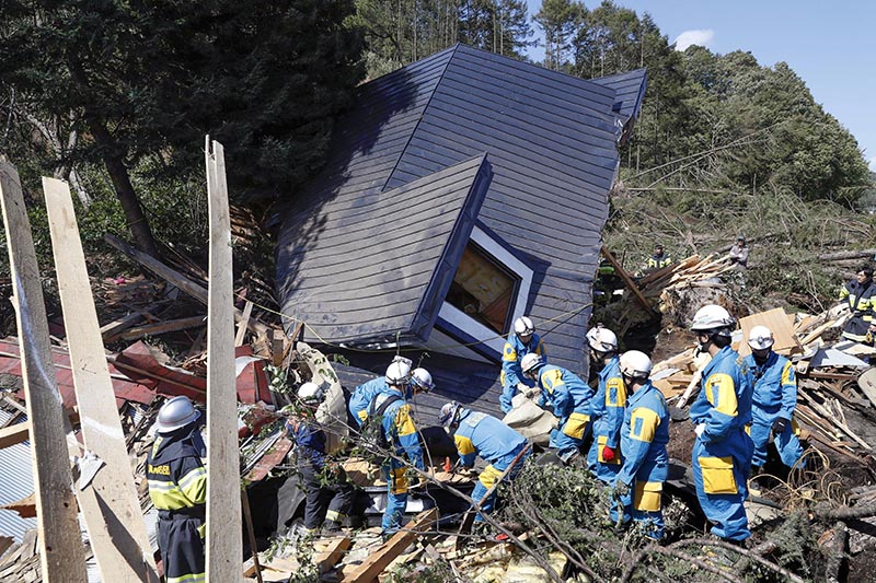 Rescue workers search for survivors from a house damaged by a landslide caused by an earthquake in Atsuma town, Hokkaido, Japan, in this photo taken by Kyodo September 6, 2018. Photo: Kyodo via Reuters