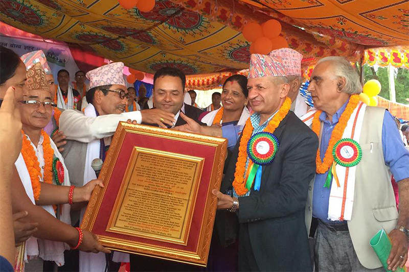 Minister Pradeep Gyawali receives bronze-notice before declaring Devchuli as children-friendly municipality in Nawalpur. Photo: Shreeram Sigdel