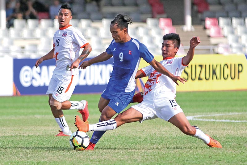 Nepalu2019s Sunil Bal vies for the ball with Bhutanu2019s Nima Wangdi (right) during their Group A match of the SAFF Championship in Dhaka on Thursday. 
