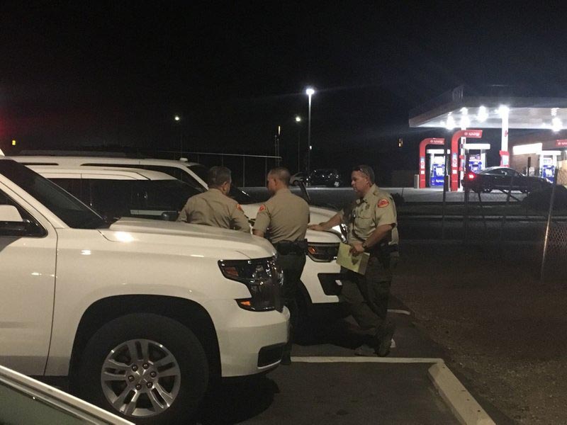 Kern County Sherrifu2019s deputies gather near the scene, Wednesday, Sept. 12, 2018, in southeast Bakersfield, Calif., where authorities say a gunman killed multiple people. (Sam Morgen/The Bakersfield Californian via AP