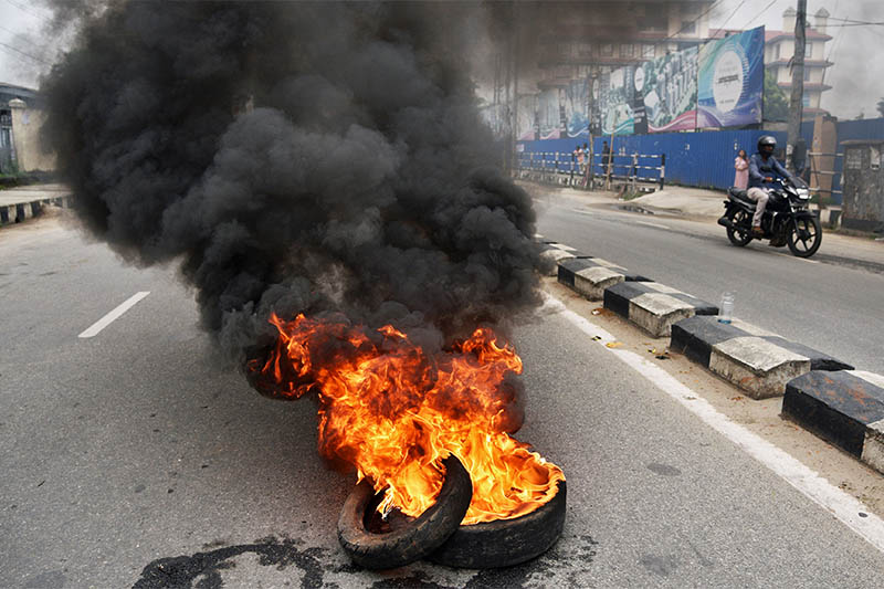 A motorcyclist rides pass burning tyres put up on fire by supporters of India's main opposition Congress party, during a nationwide strike against hike in fuel prices, in Guwahati, India September 10, 2018. Photo: Reuters