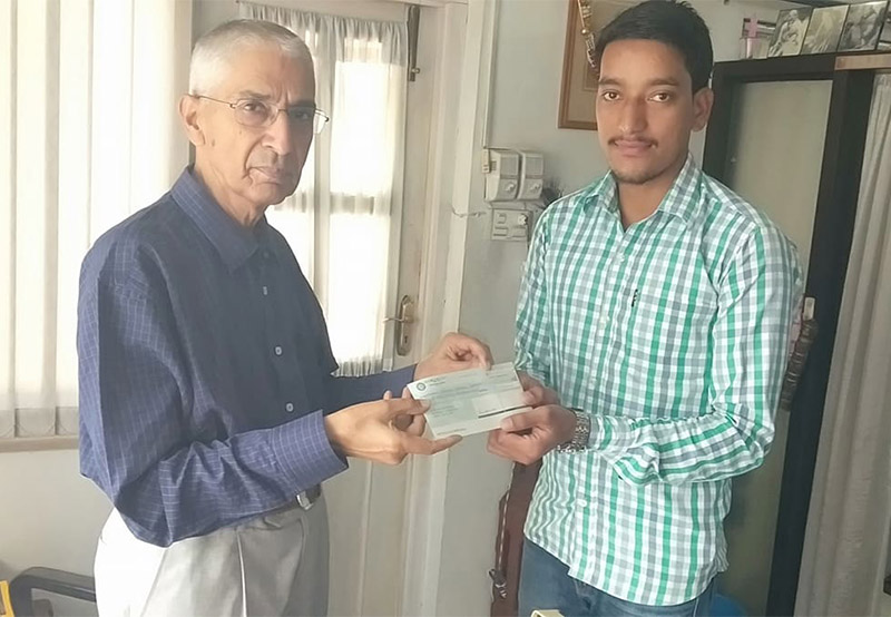 President of Sai Samaj Sewa Nidhi, Sundarmani Dixit, handing over a cheque of Rs 50,000 to the kin of 17-year-old Shiva Rokaya, who had been living with a fractured leg for the past four months. Photo: Prakash Singh/THT