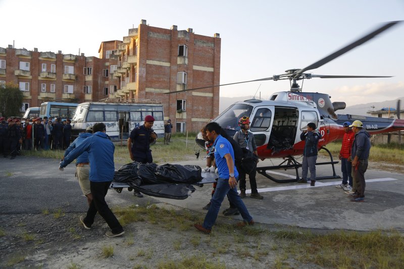 Officials unload the bodies after a helicopter carrying bodies of those killed in Gurja Himal mountain arrives at the Teaching hospital in Kathmandu, Nepal, on Sunday, Oct. 14, 2018. Photo: AP