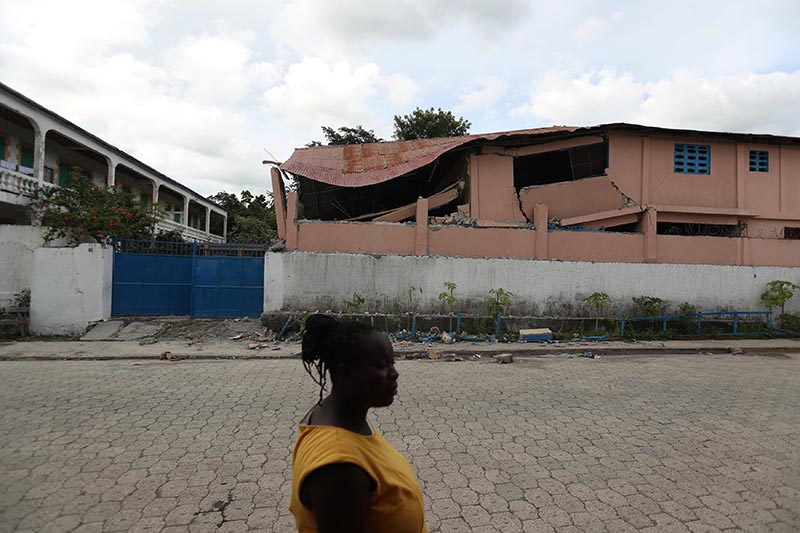 A woman walks in front of a school damaged in an earthquake, that hit northern Haiti late on Saturday, in Gros Morne, Haiti, October 8, 2018. Photo: Reuters